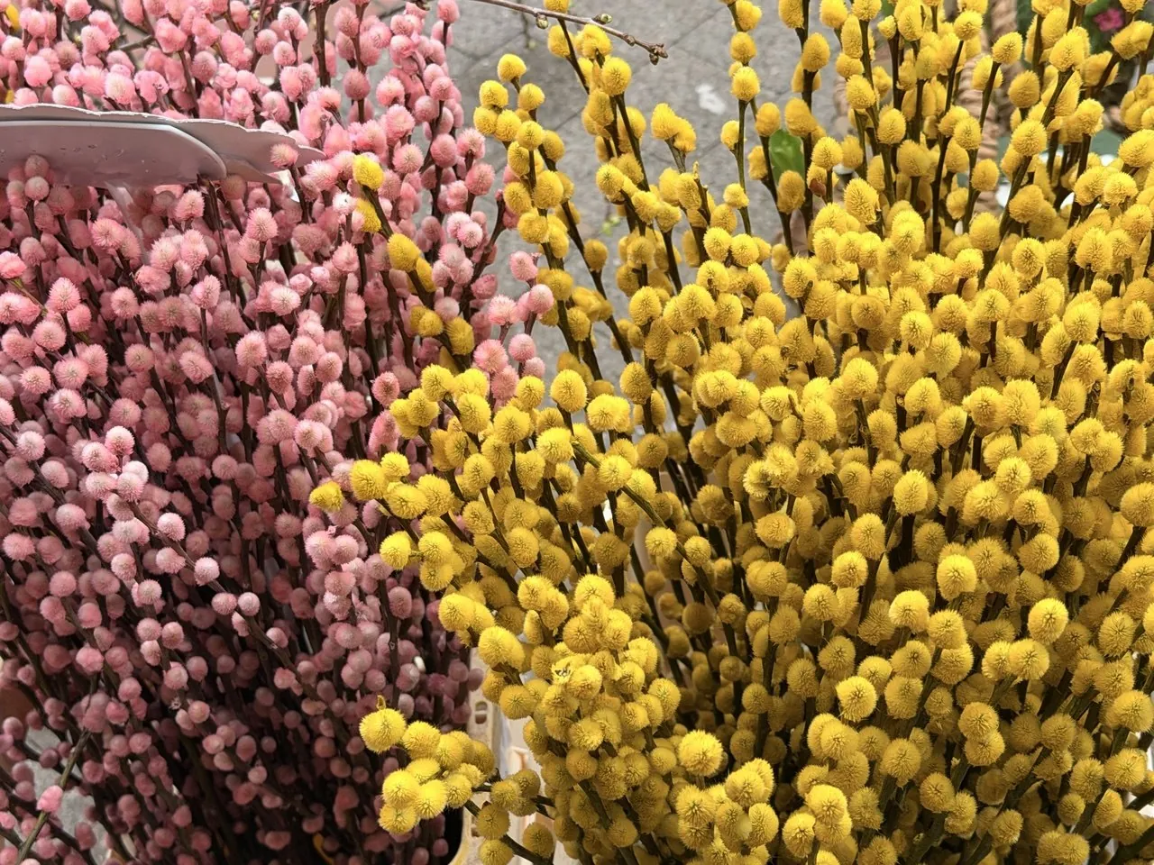 Ramas de flores rosas y amarillas en un mercado