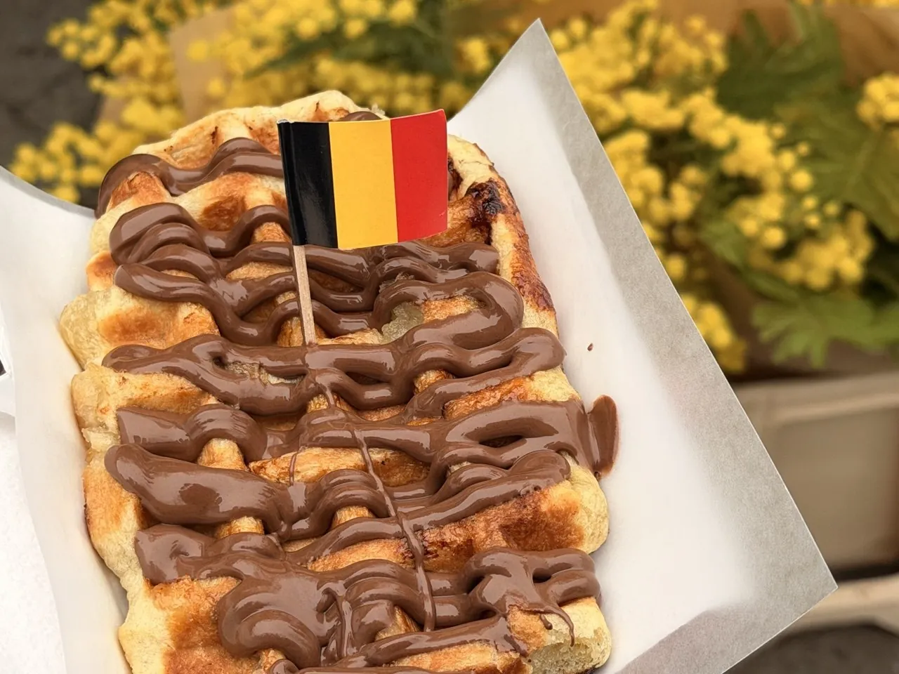 Gofre con chocolate y una bandera de Bélgica