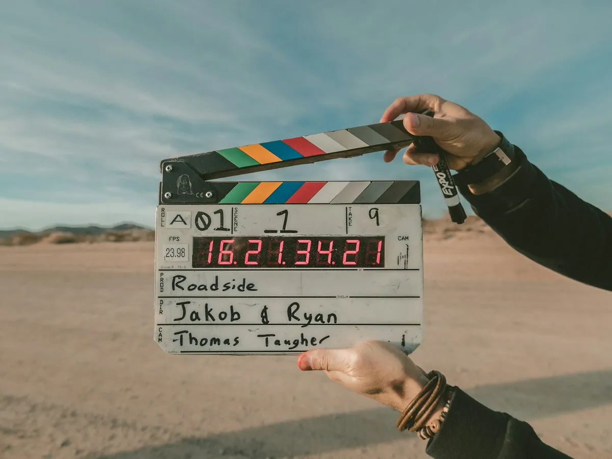 Claqueta de cine sostenida en una carretera del desierto