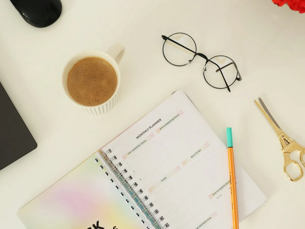 Agenda semanal, café y gafas sobre un escritorio ordenado