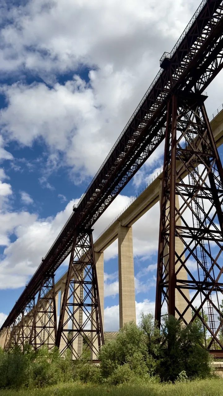 Viaducto de hierro visto desde abajo con nubes